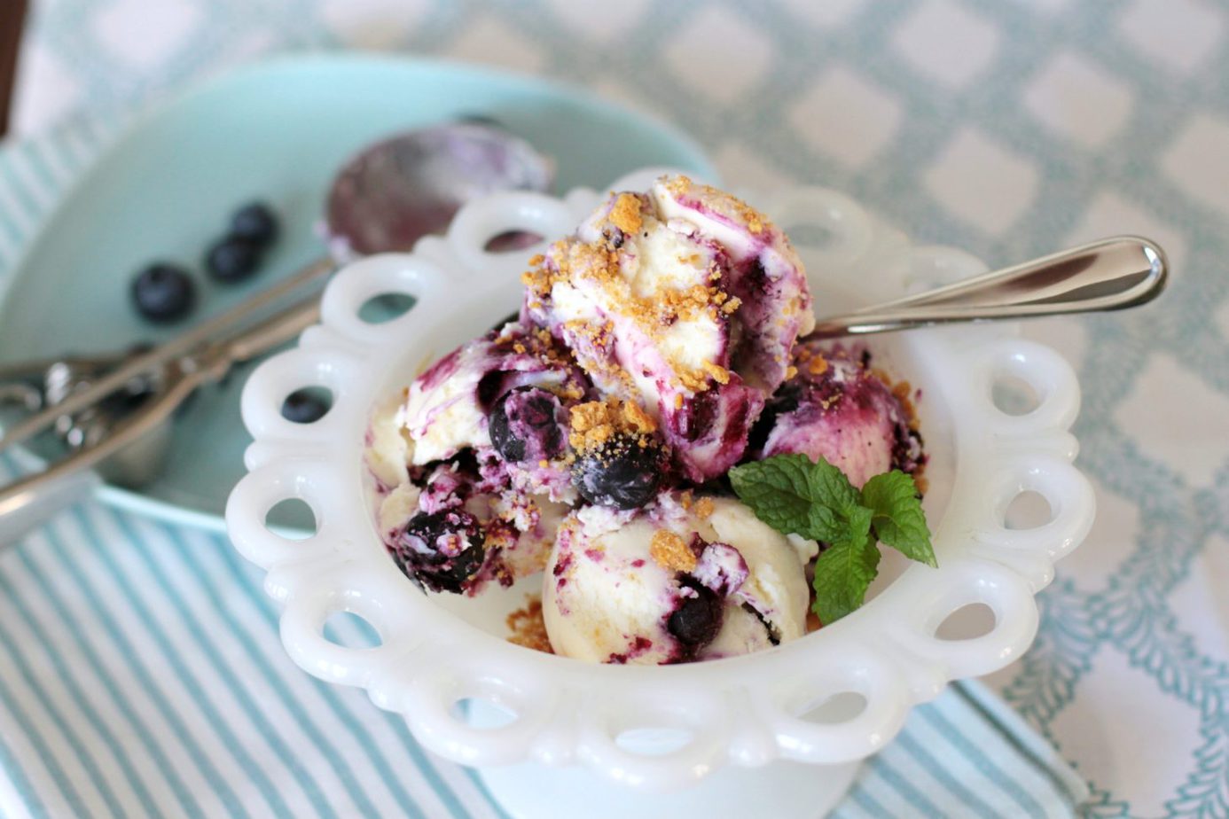 A vintage bowl filled with scoops of blueberry cheesecake ice cream.