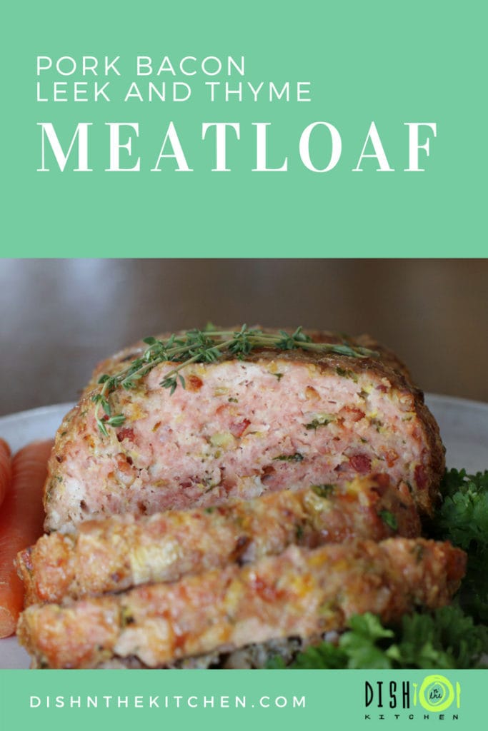 Pinterest image of a sliced pork meatloaf topped with thyme and surrounded by carrots and kale.