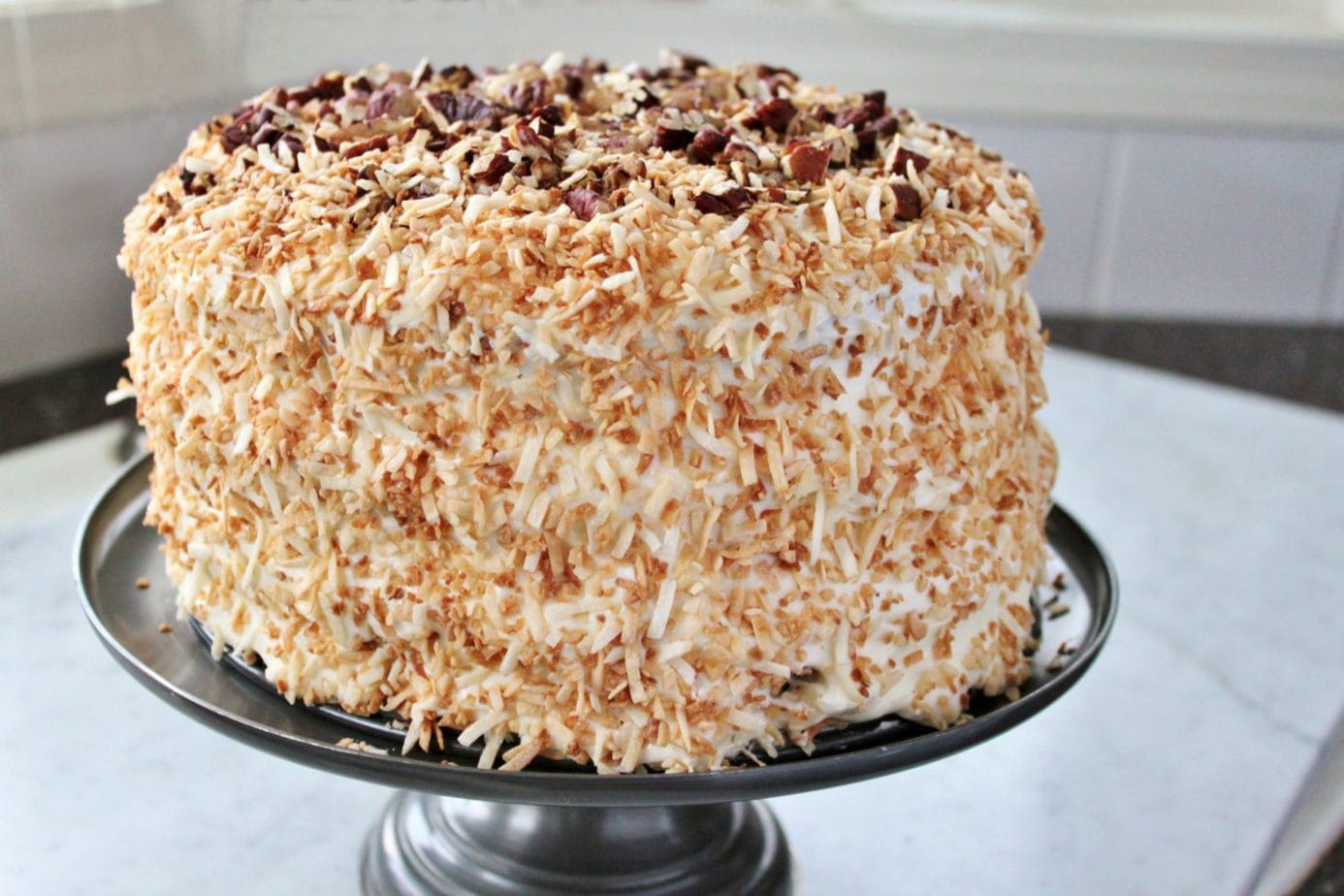 A decadent cream cake with pecans and coconut
