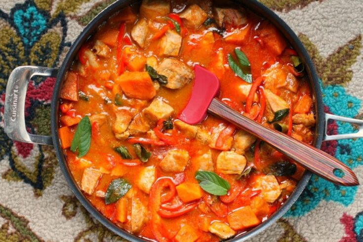 A large pan full of vibrant Pork and Mango Curry.