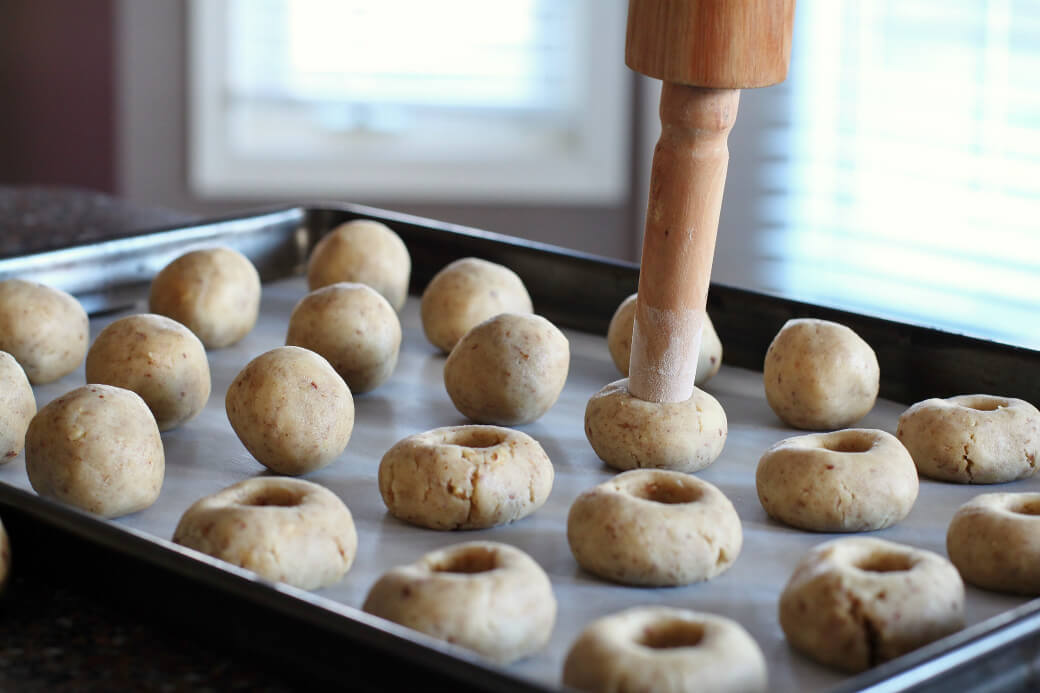Pecan Polvorones - cookie holes being formed by pressing a rolling pin handle downward.