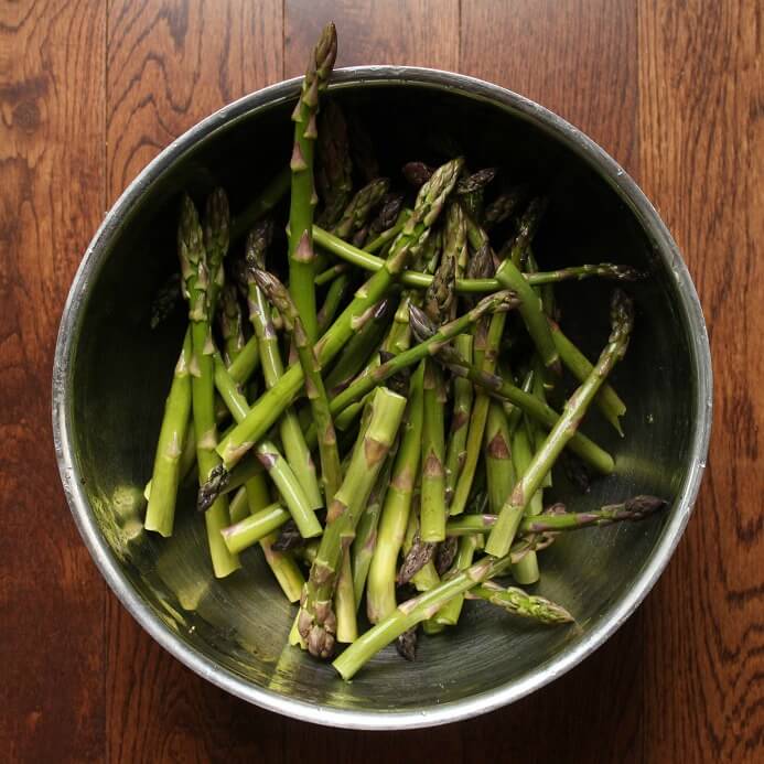 A bowl containing fresh green asparagus