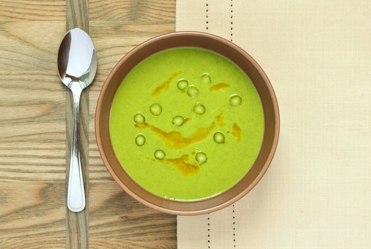 A bowl of bright green asparagus soup