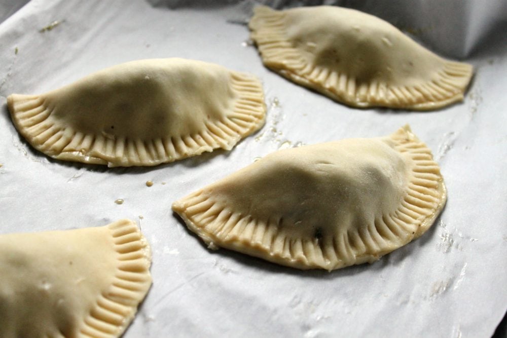 Folded mushroom hand pies ready to bake.