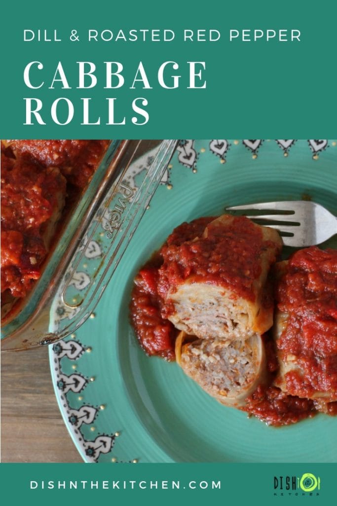 Cabbage rolls filled with meat and rice and covered with a red tomato sauce on a teal plate. 