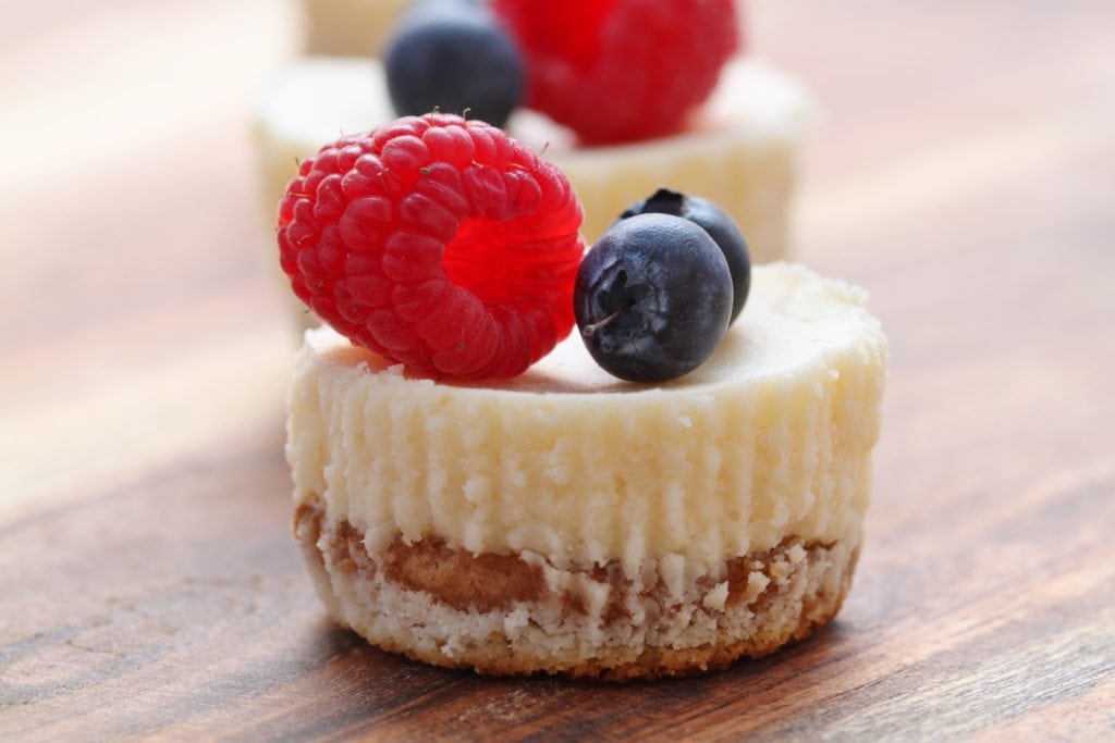 Bite Sized Cheesecakes Close up of a cheesecake with berries on top.