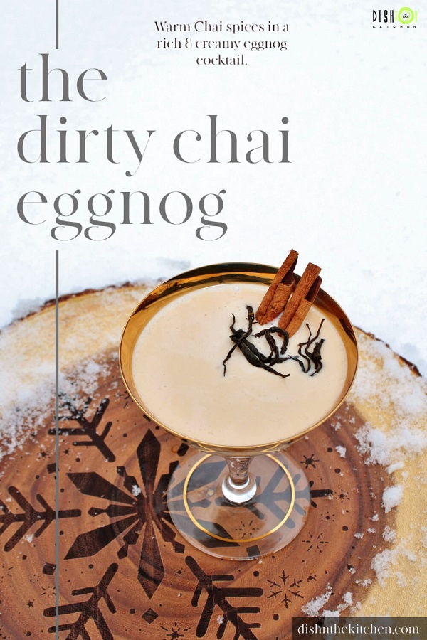 Pinterest image of a Dirty Chai Cocktail - A gold rimmed coupe glass holds a creamy cocktail garnished with cinnamon sticks and black tea. 