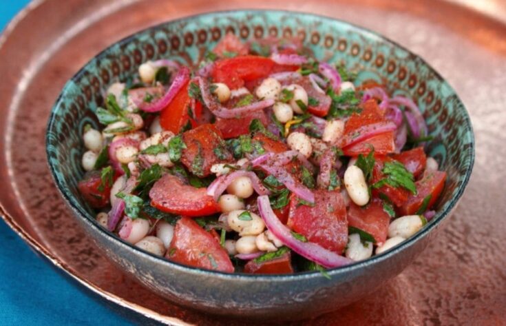 A mouthwatering yet simple piyaz saladin a vibrant glass bowl.
