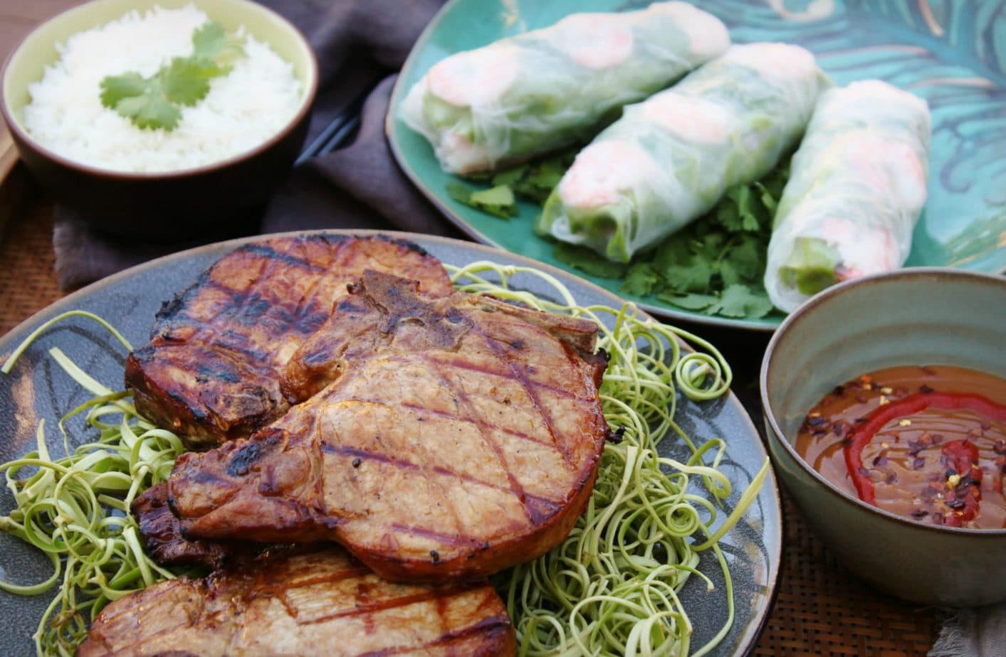 A platter of grilled pork chops and some Vietnamese Salad rolls.