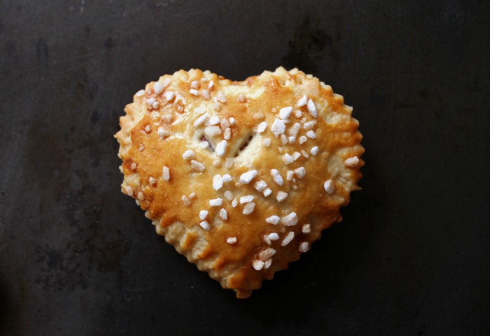 A golden baked heart shaped hand pie filled with Sour Cherries and Cream cheese.