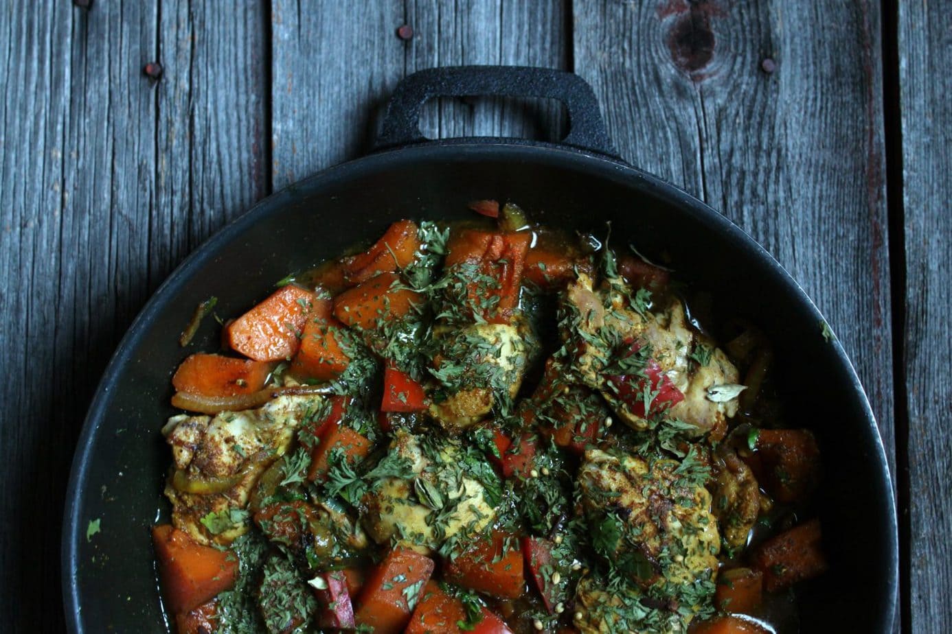 A tajine filled with bright butternut squash and chicken.