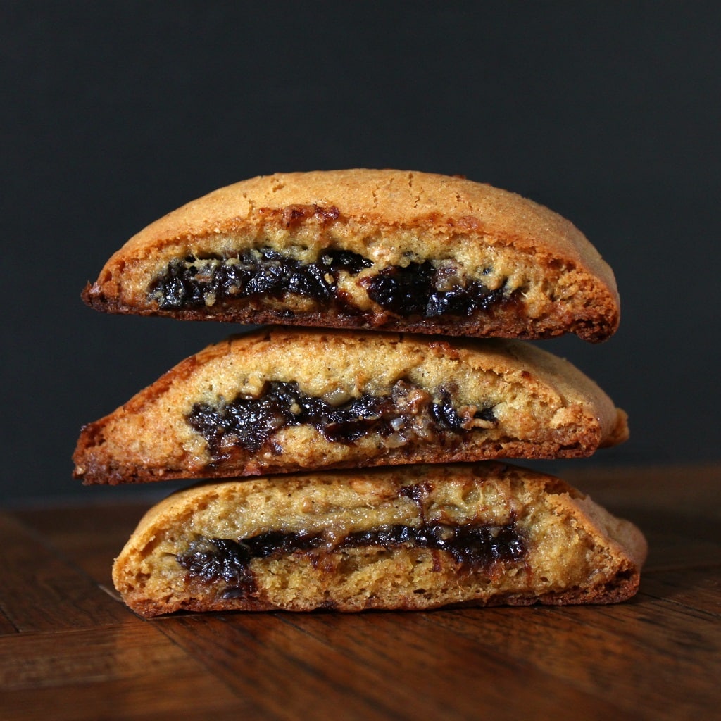 A stack of three homemade fig newtons against a black background.