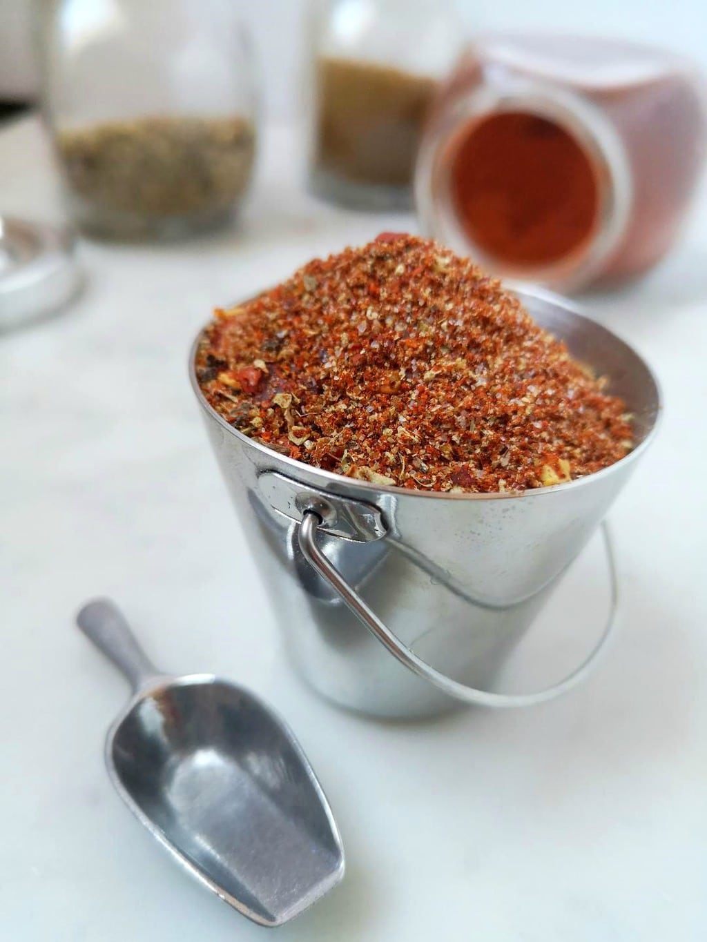A tiny silver bucket filled with taco seasoning mix.