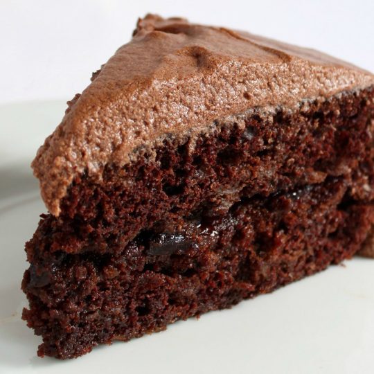Sauerkraut Chocolate Cake - A generous slice of frosted chocolate cake on a white plate.