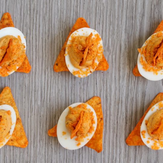 These Zesty Nacho Deviled Eggs have all the flavour of classic deviled eggs plus a kick of taco spice and the crunch of Dorito crumbs. Perfect for game day, potluck, or any family gathering. #deviledeggs #doritocrumb #nachoeggs #nachodeviledeggs