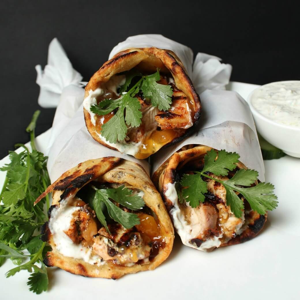 grilled chicken wrapped in paratha along with cilantro, mango chutney, and raita.