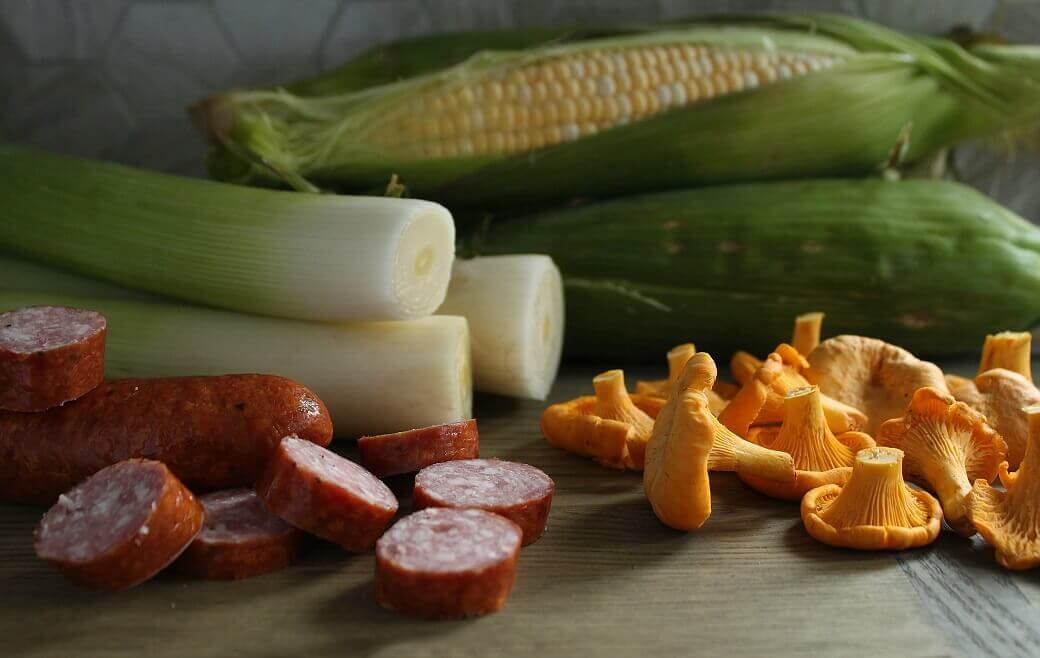 Hearty Farmer's Sausage Sweet Corn Chowder - Ingredients featuring Fresh corn on the cob, leeks, golden chanterelles, and Farmer's Sausge.