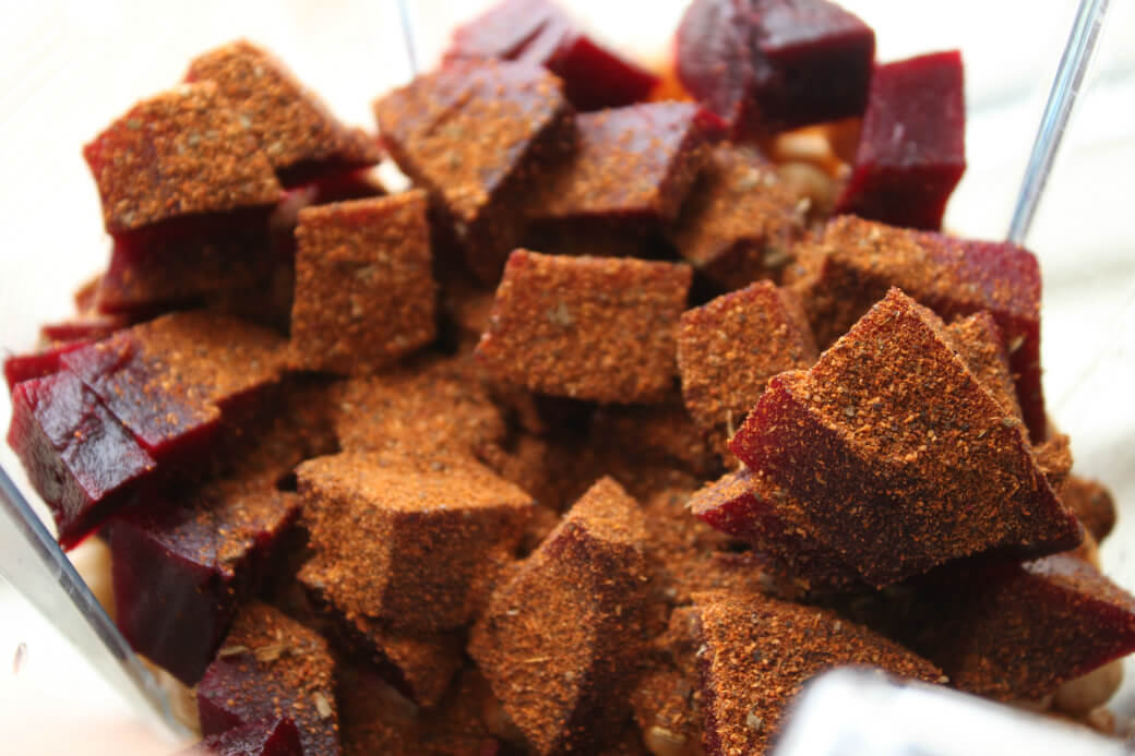 Baharat Roasted Beet Hummus -Roasted beet cubes covered in spices in the bowl of a food processor.