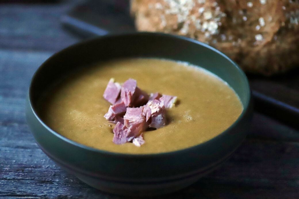Split Pea and Ham Soup - A bowl of satin smooth green split pea soup topped with ham.
