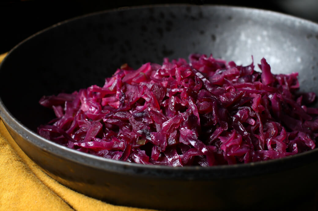 Bright purple shredded red cabbage in a black bowl.