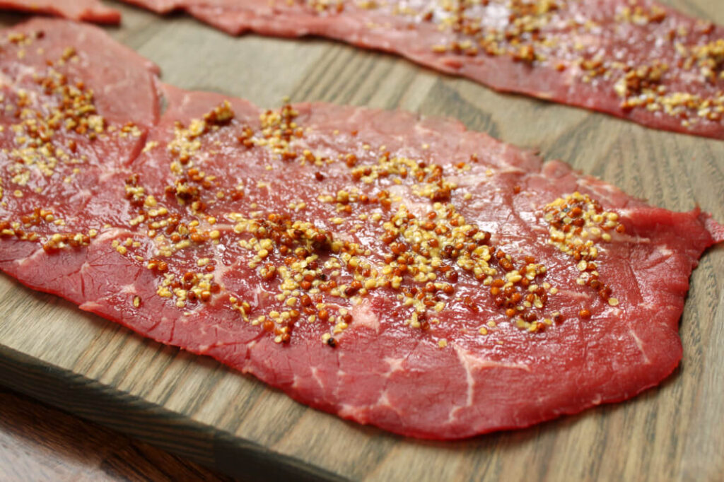 One beef roulade spread with grainy mustard.