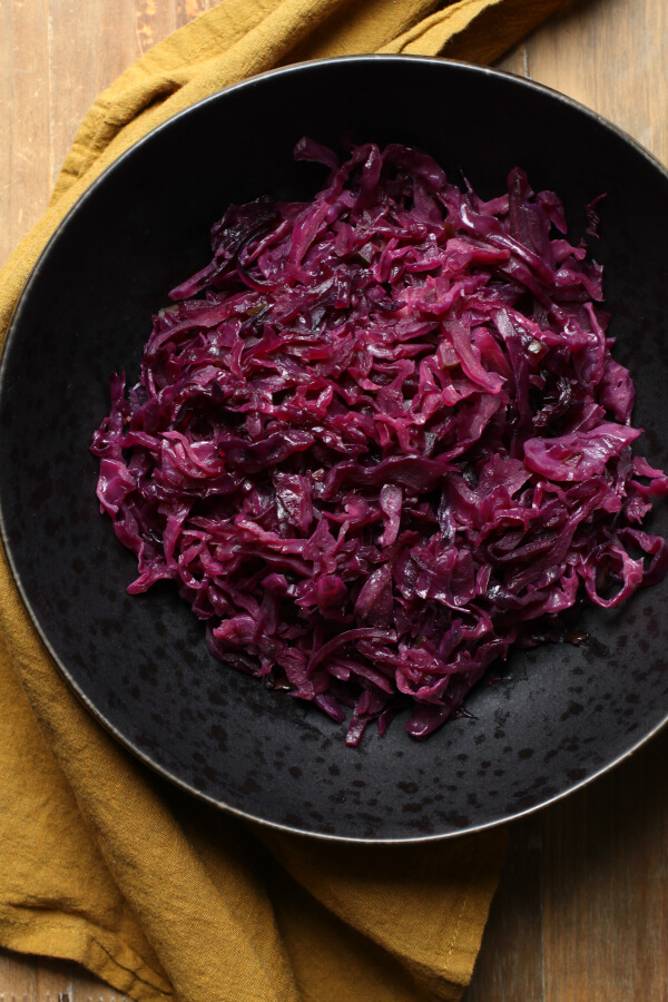 Bright purple shredded red cabbage in a black bowl.