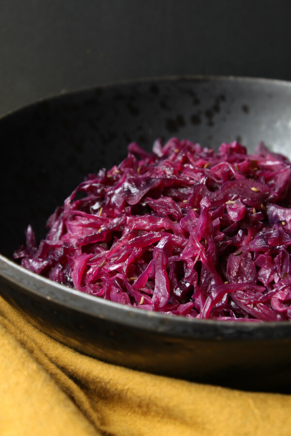 Bright purple shredded red cabbage in a black bowl.