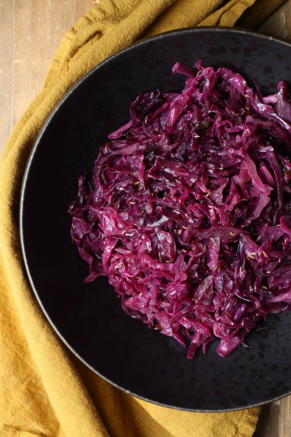 Bright purple shredded red cabbage in a black bowl.