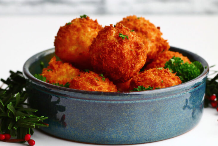 A blue bowl filled with golden fried goat cheese balls.