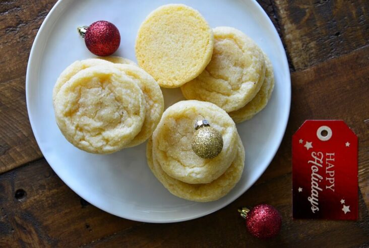 Eggnog Cookies on a white plate with Christmas ball decorations.