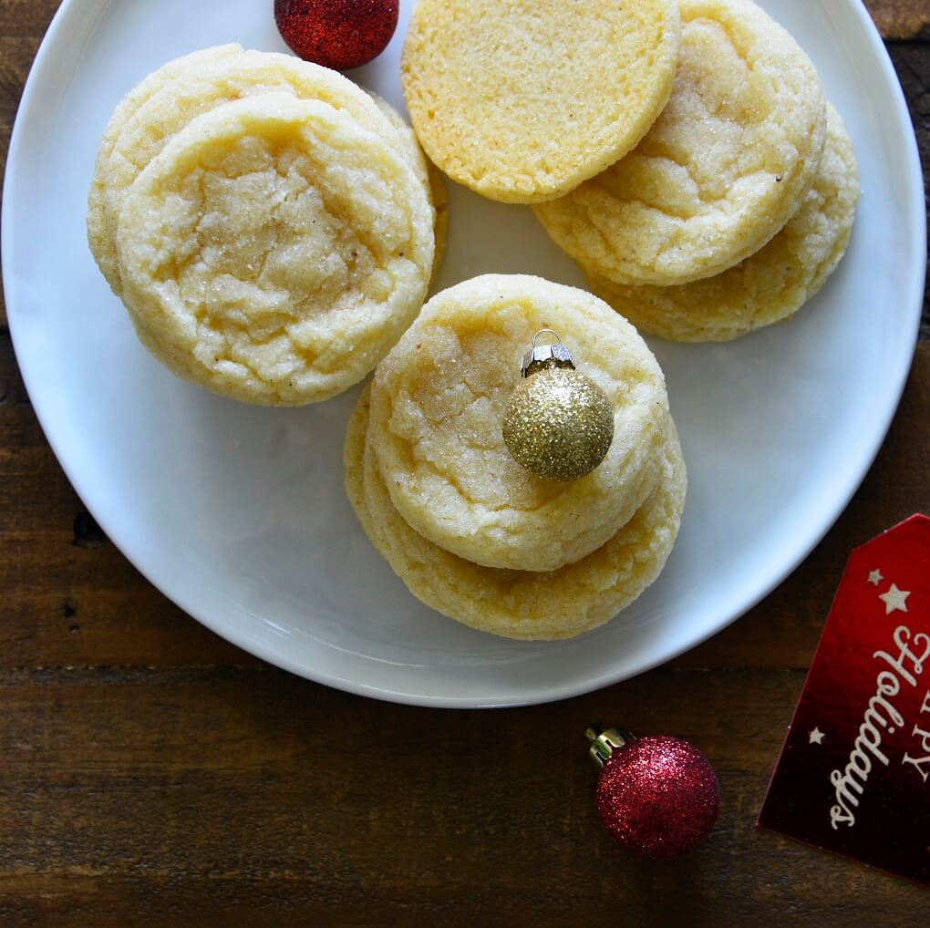 Eggnog Cookies on a white plate with Christmas ball decorations.