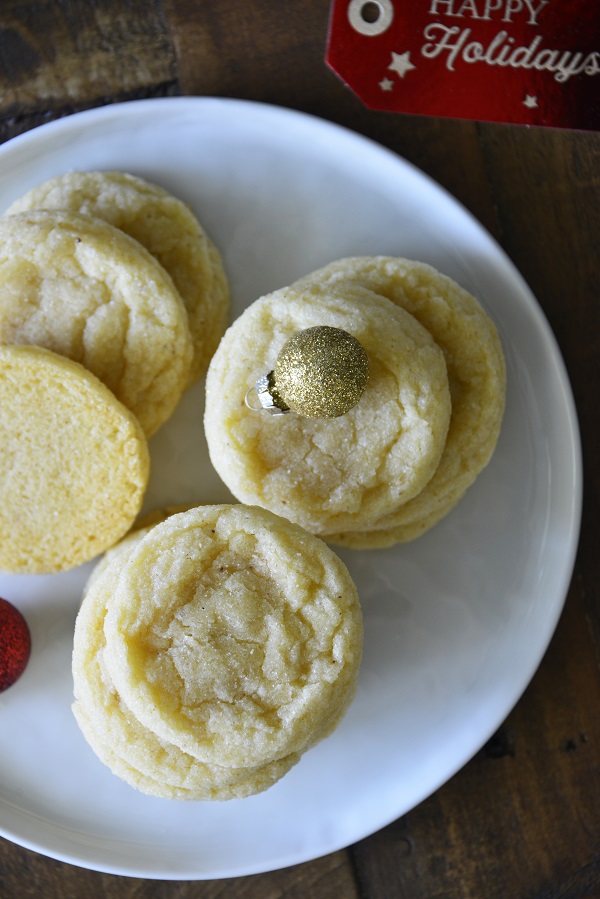 Eggnog Cookies on a white plate with Christmas ball decorations.