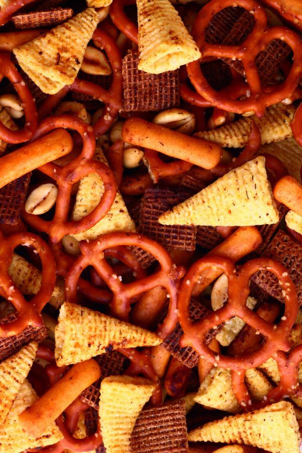 Close view of Bugles, pretzels, peanuts, Shreddies, and Cheese sticks.