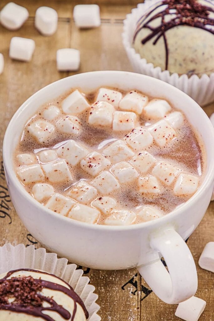 A white mug filled with creamy hot chocolate and floating mini marshmallows.