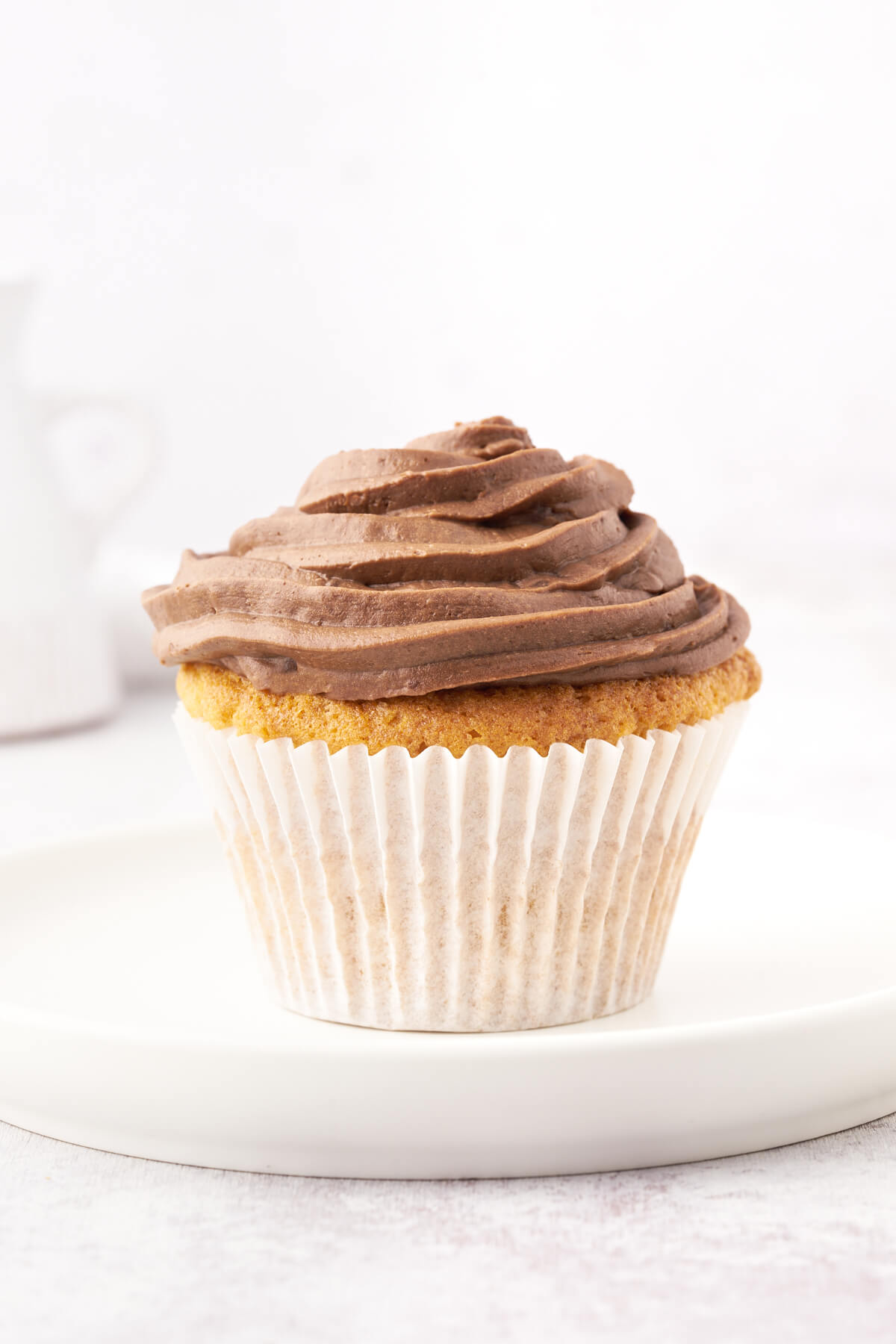 A vanilla cupcake frosted with swirled Nutella frosting.