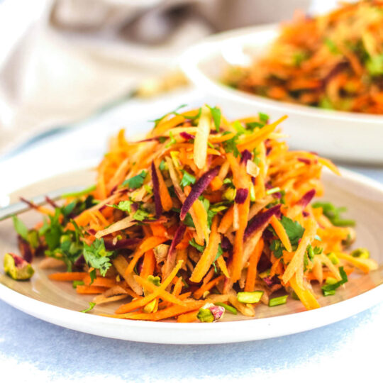 A white plate filled with colourful grated carrot salad.
