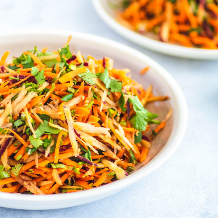 A white plate filled with colourful grated carrot salad.