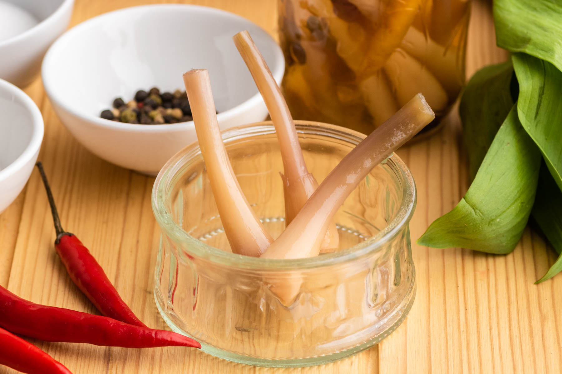 A small glass dish containing pickled ramps.