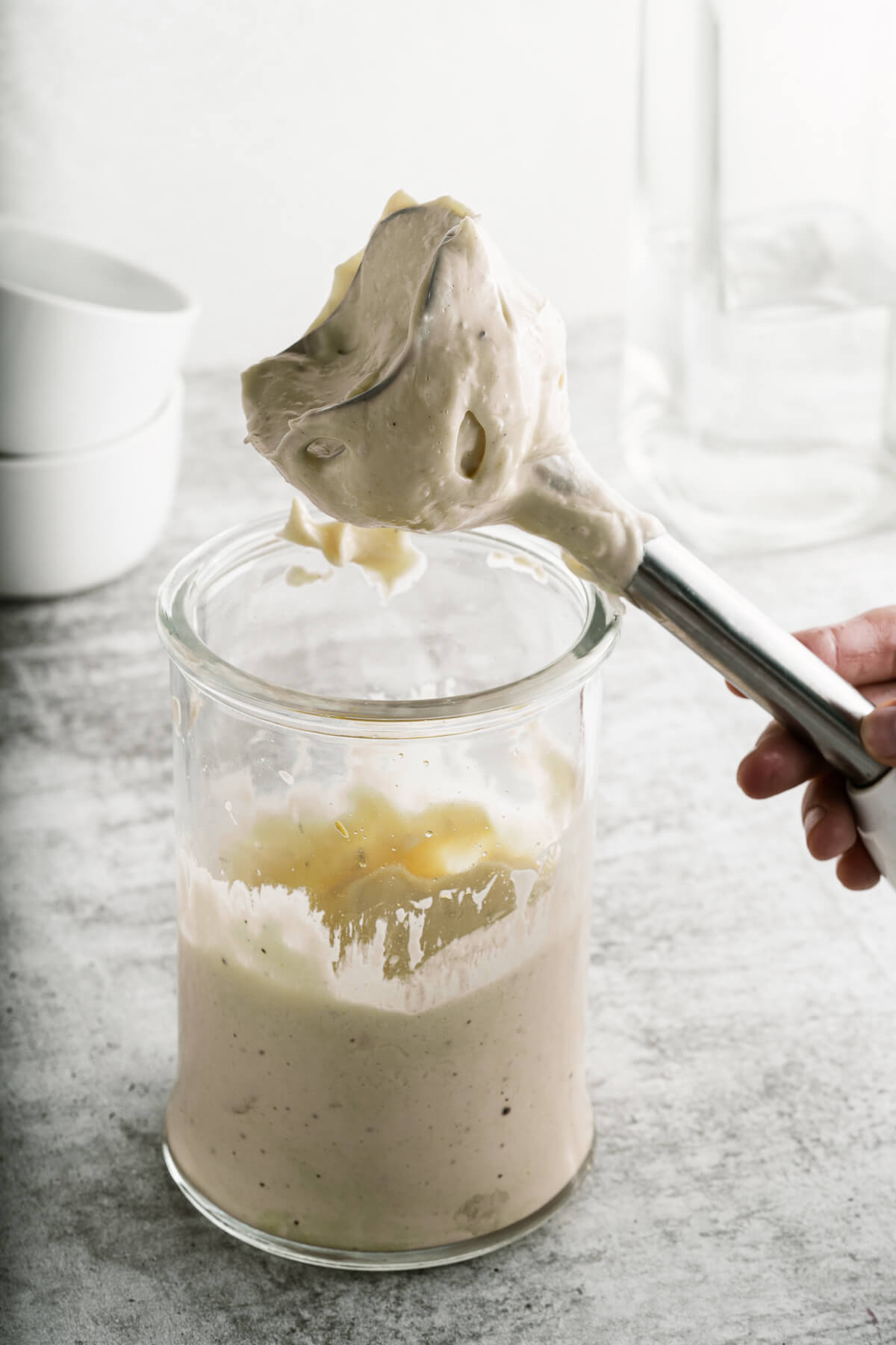 An immersion blender with aioli on it.