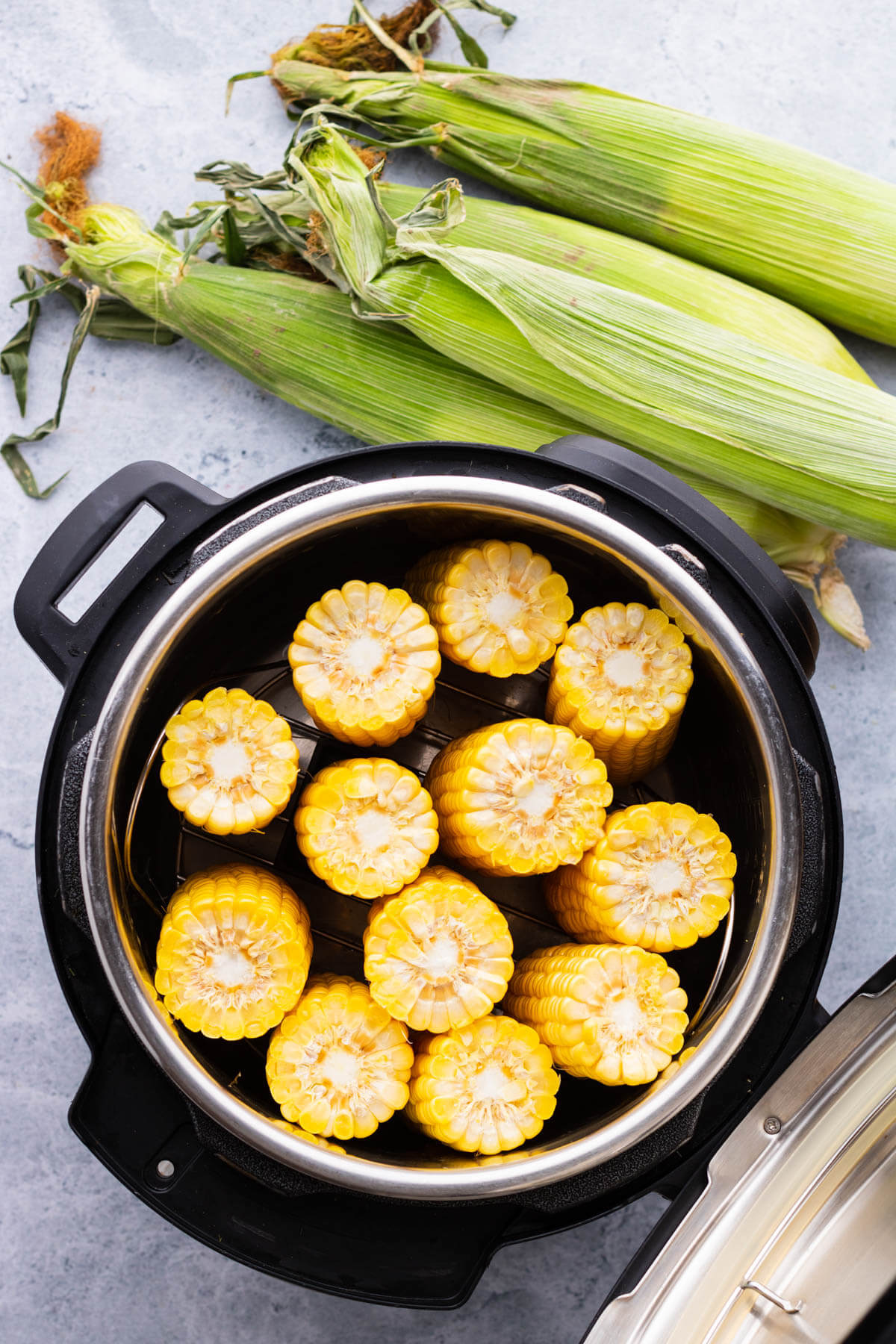 Raw corn arranged inside an Instant Pot.