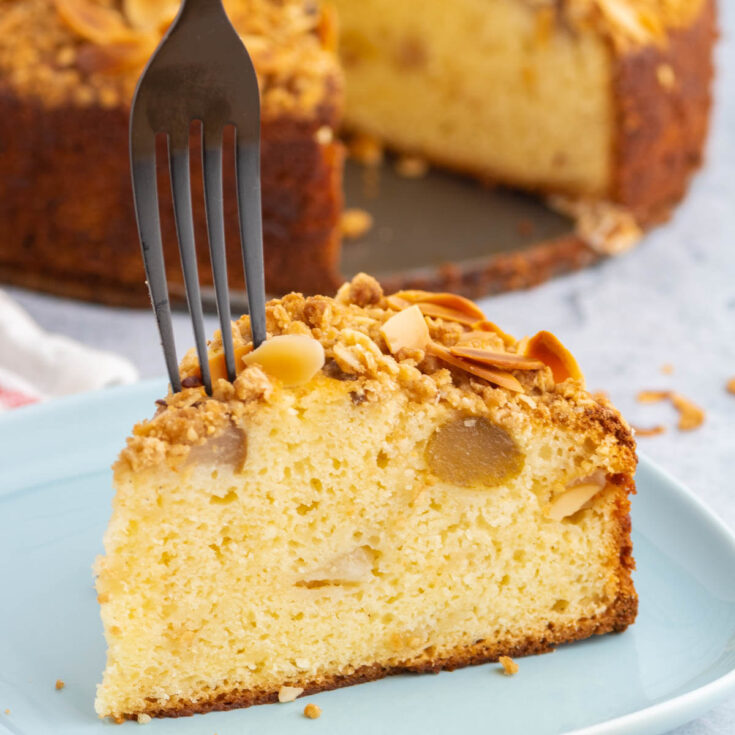 A fork cutting into a slice of Pear Ricotta Cake.