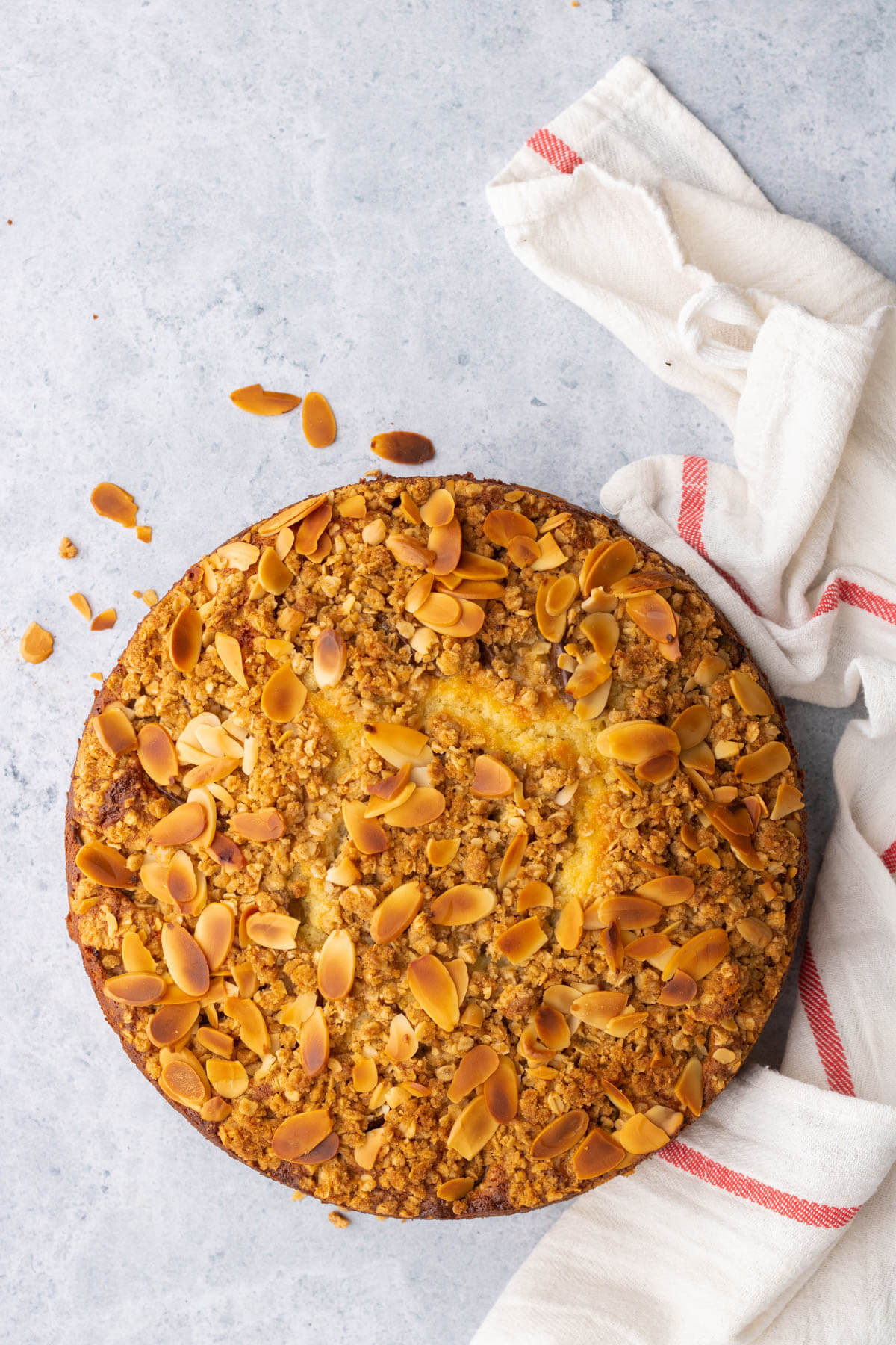 Overhead view of a golden almond crumble topped ricotta cake.
