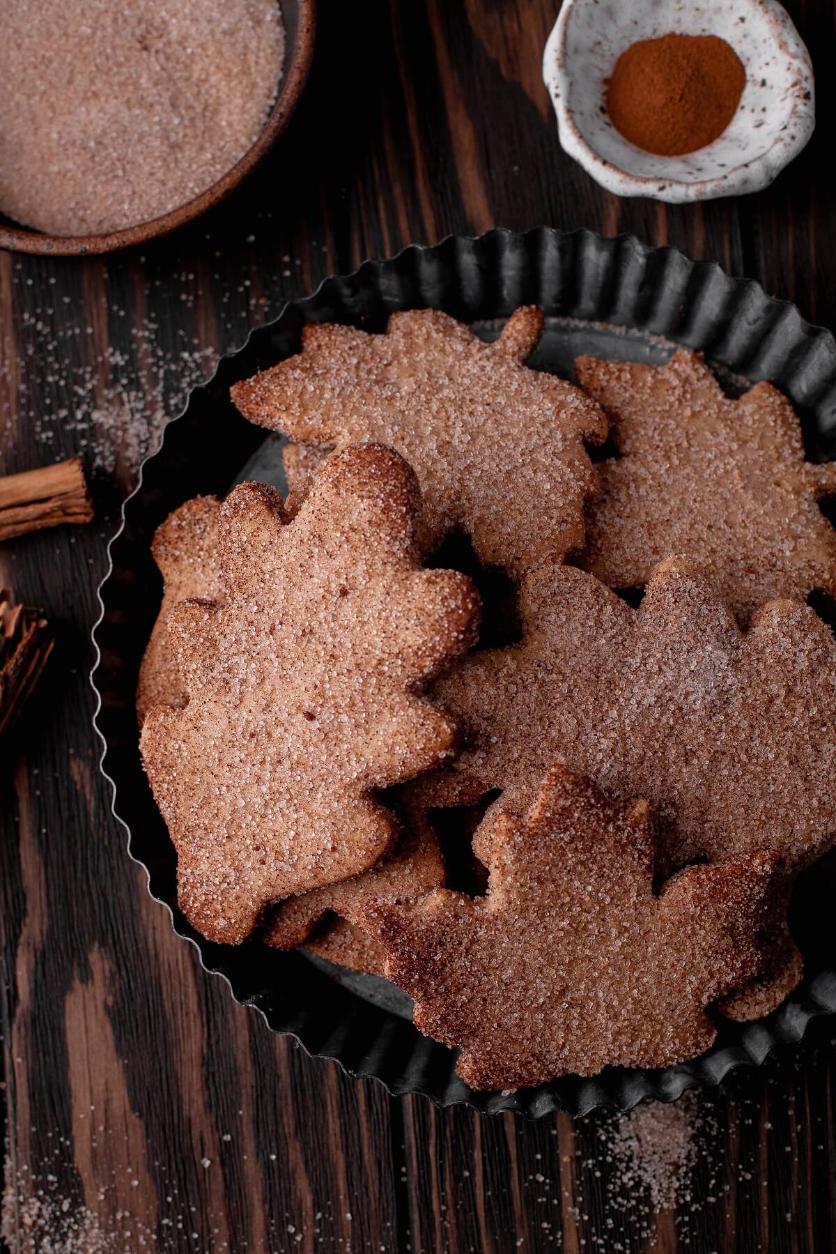 A tin plate filled with leaf shaped Walnut Cookies coated in cinnamon sugar.