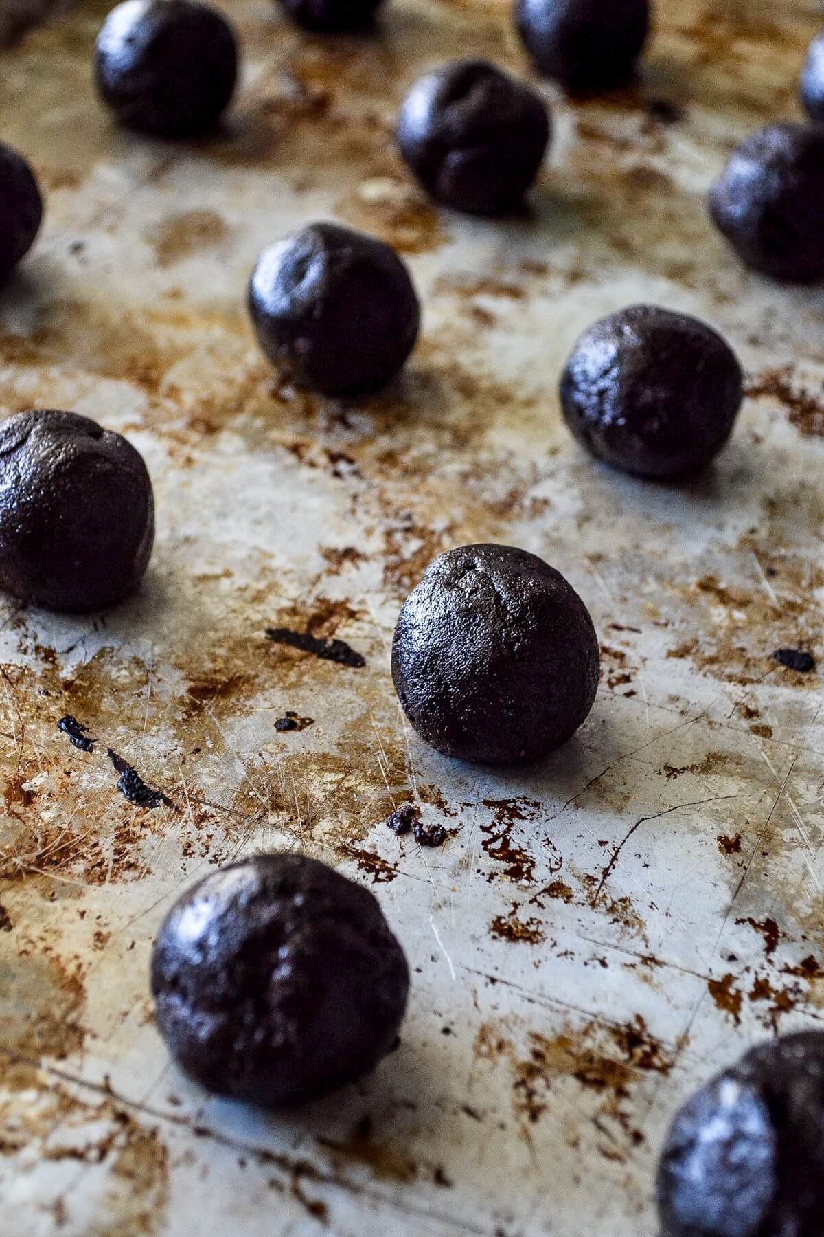 Oreo truffle balls sit on a baking sheet prior to being coated in white chocolate.