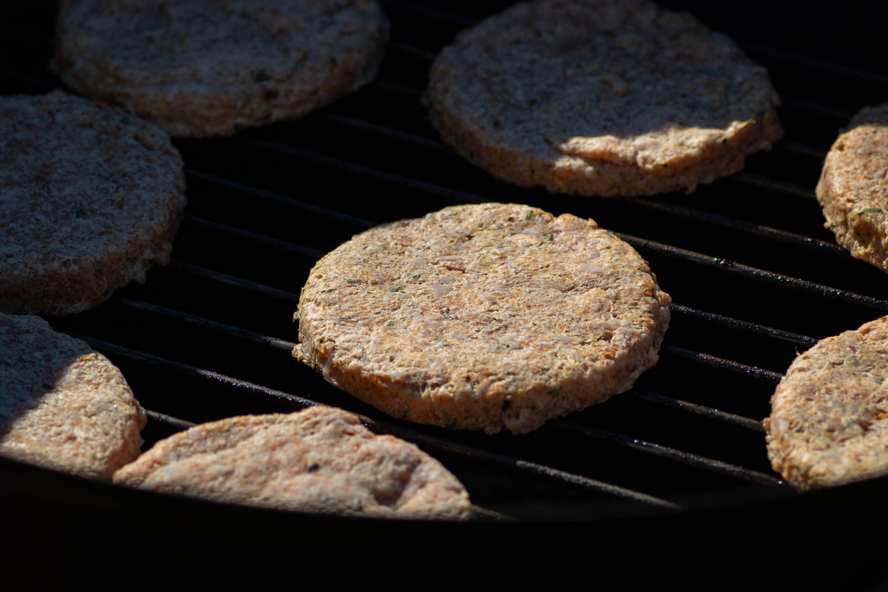 Breakfast sausage patties being smoked in a smoker.