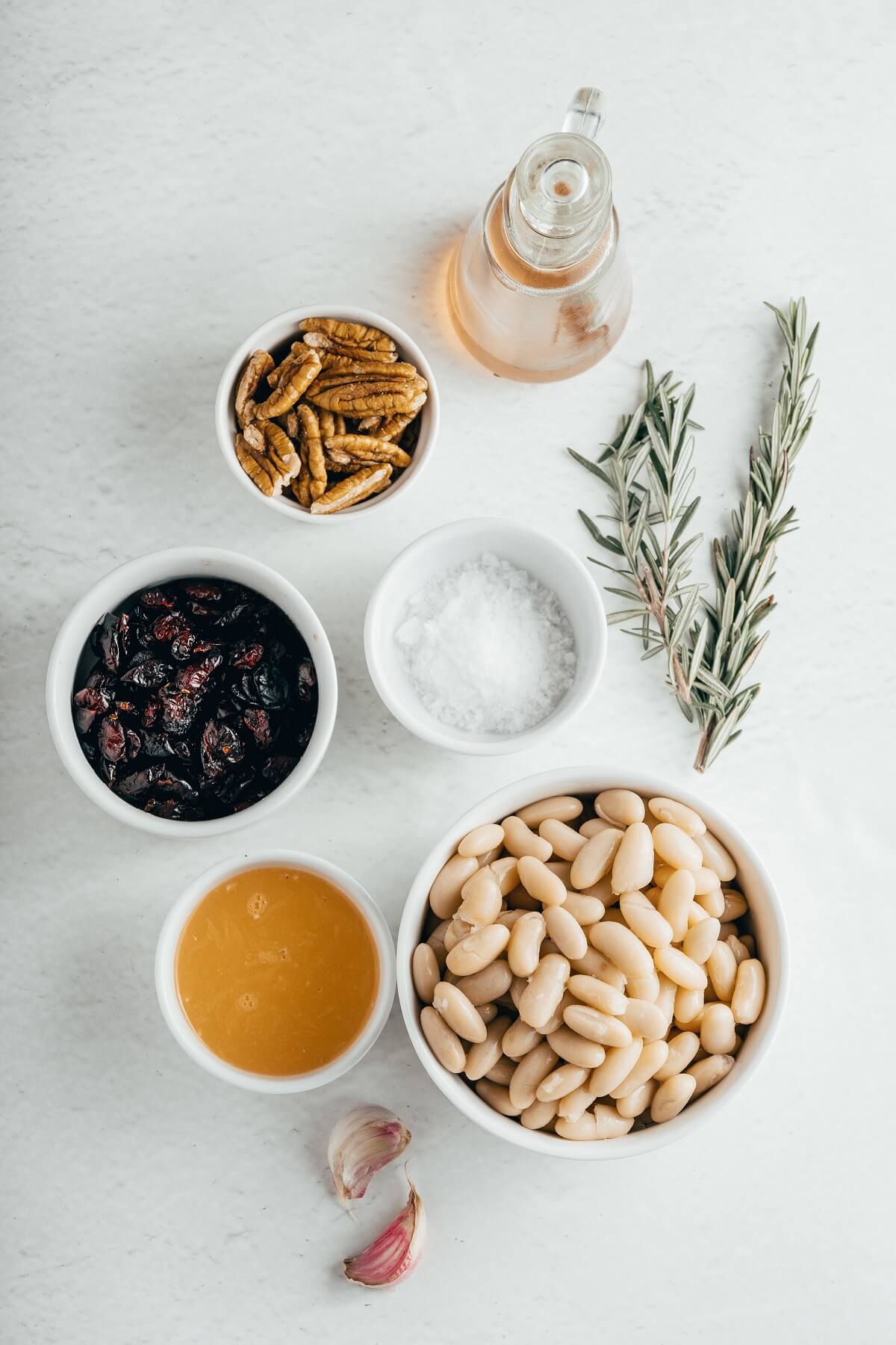 Ingredients required to make white bean hummus with dried cranberries and rosemary.