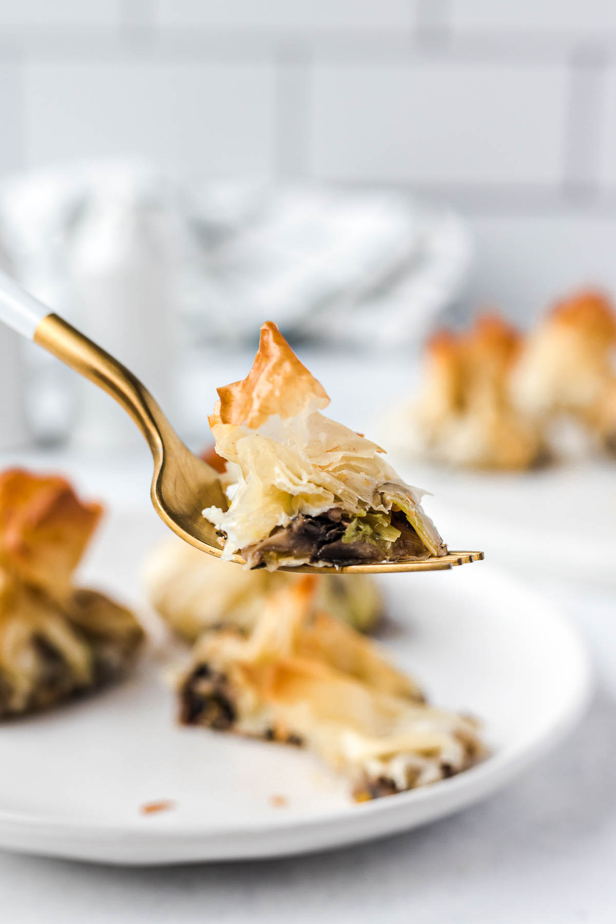 An open mushroom goat cheese filled filo pastry parcel on a fork.