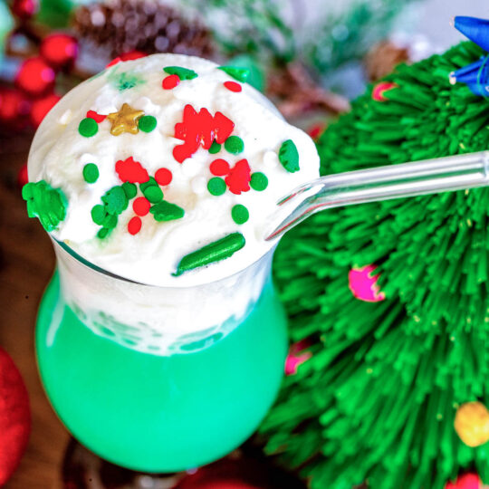 Overhead view of a Blue Hawaiian Cocktail topped with whipped cream and christmas sprinkles.