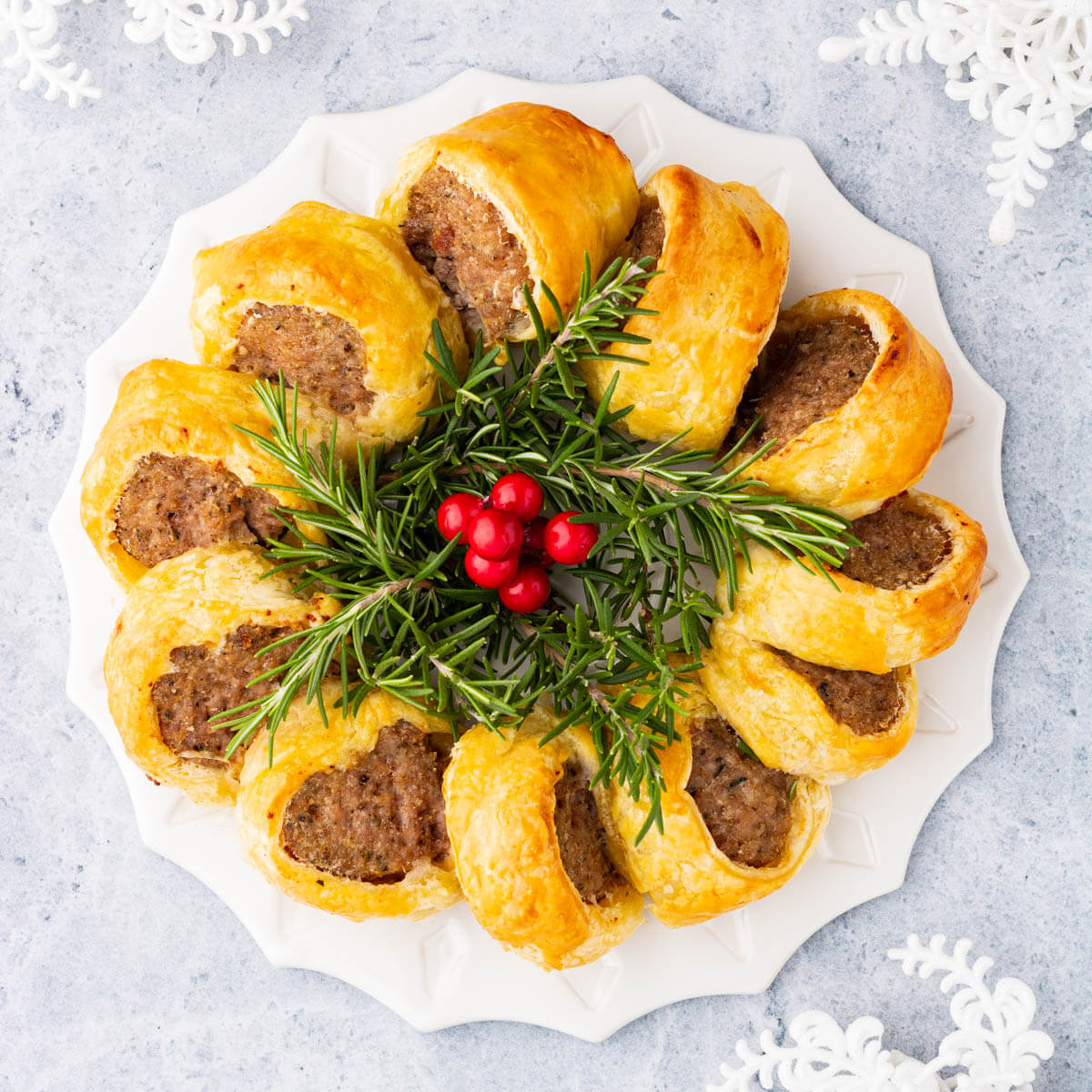Golden baked Sausage Rolls in a wreath shape.