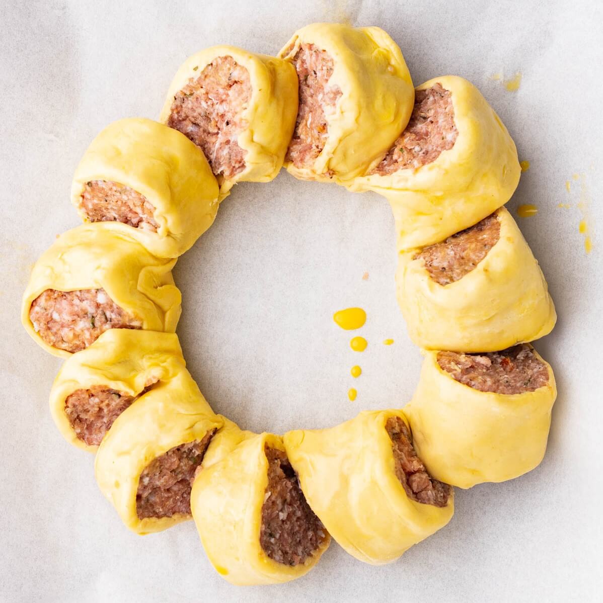 An unbaked sausage roll wreath.